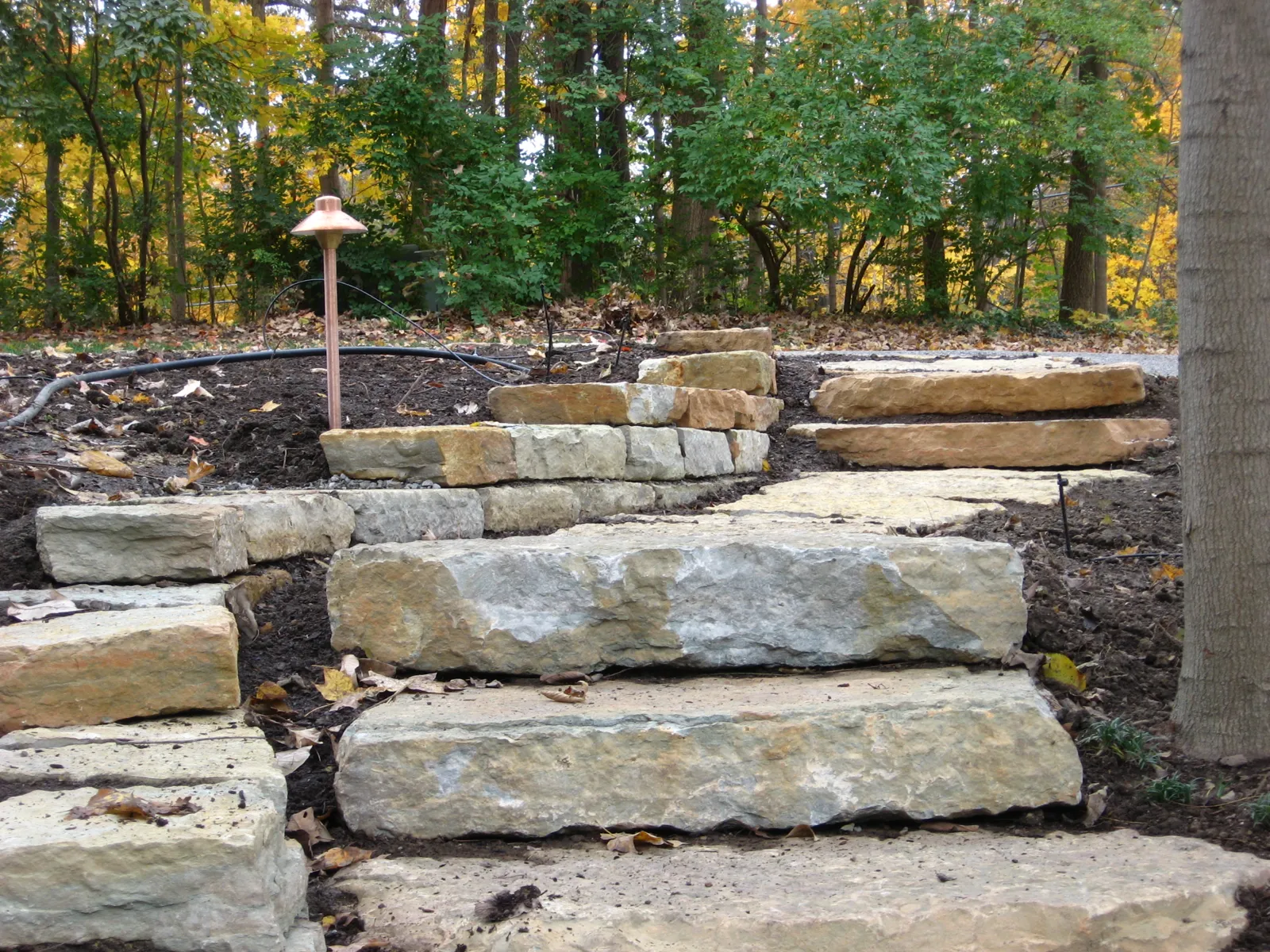 Oversized limestone slab steps set into a planted slope
