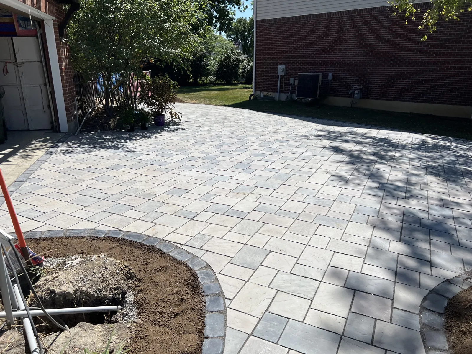 Paver driveway apron with circular border planting beds