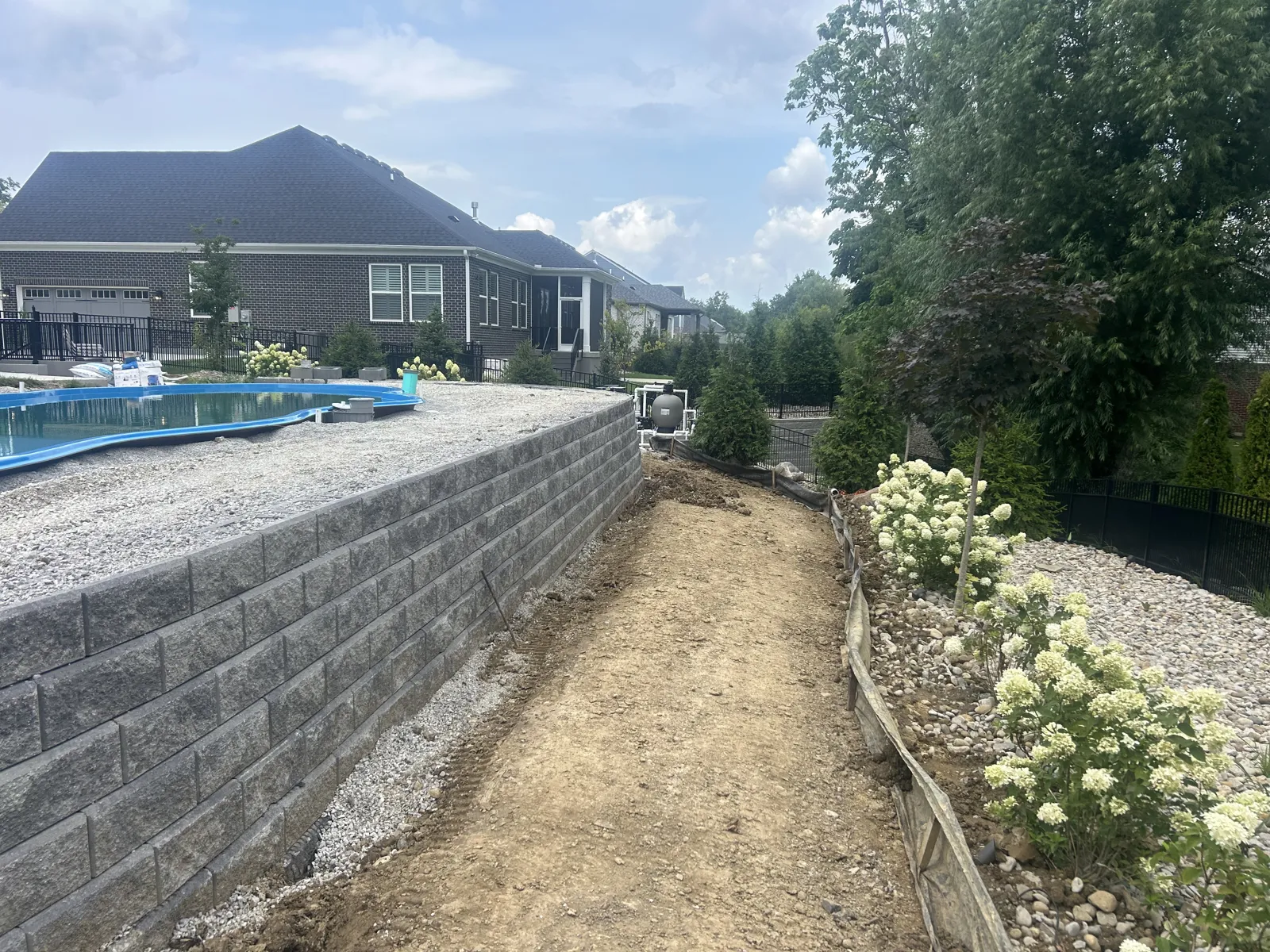 Tall segmental retaining wall with hydrangea border
