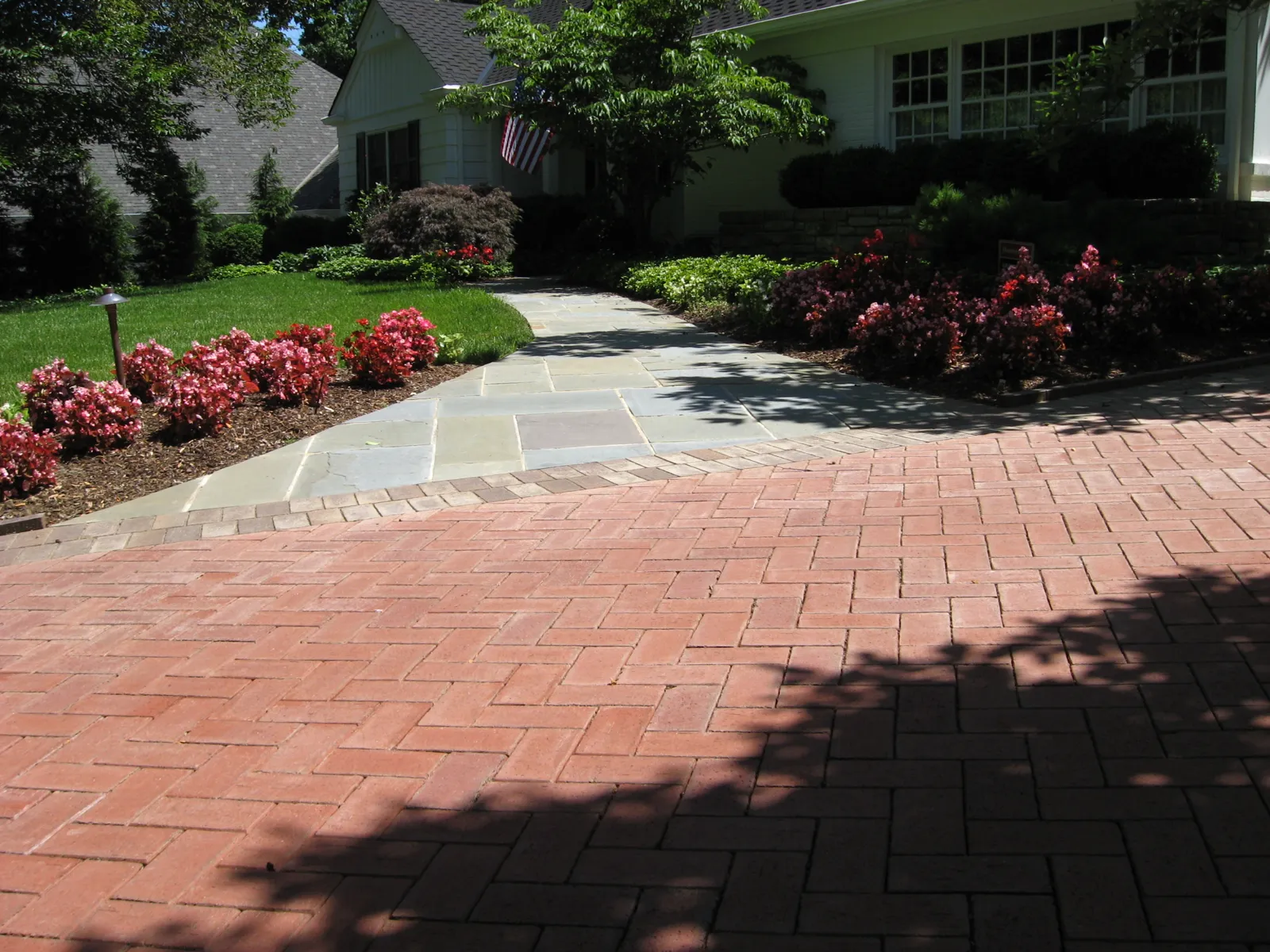 Herringbone brick paver driveway with bluestone walk and flower beds