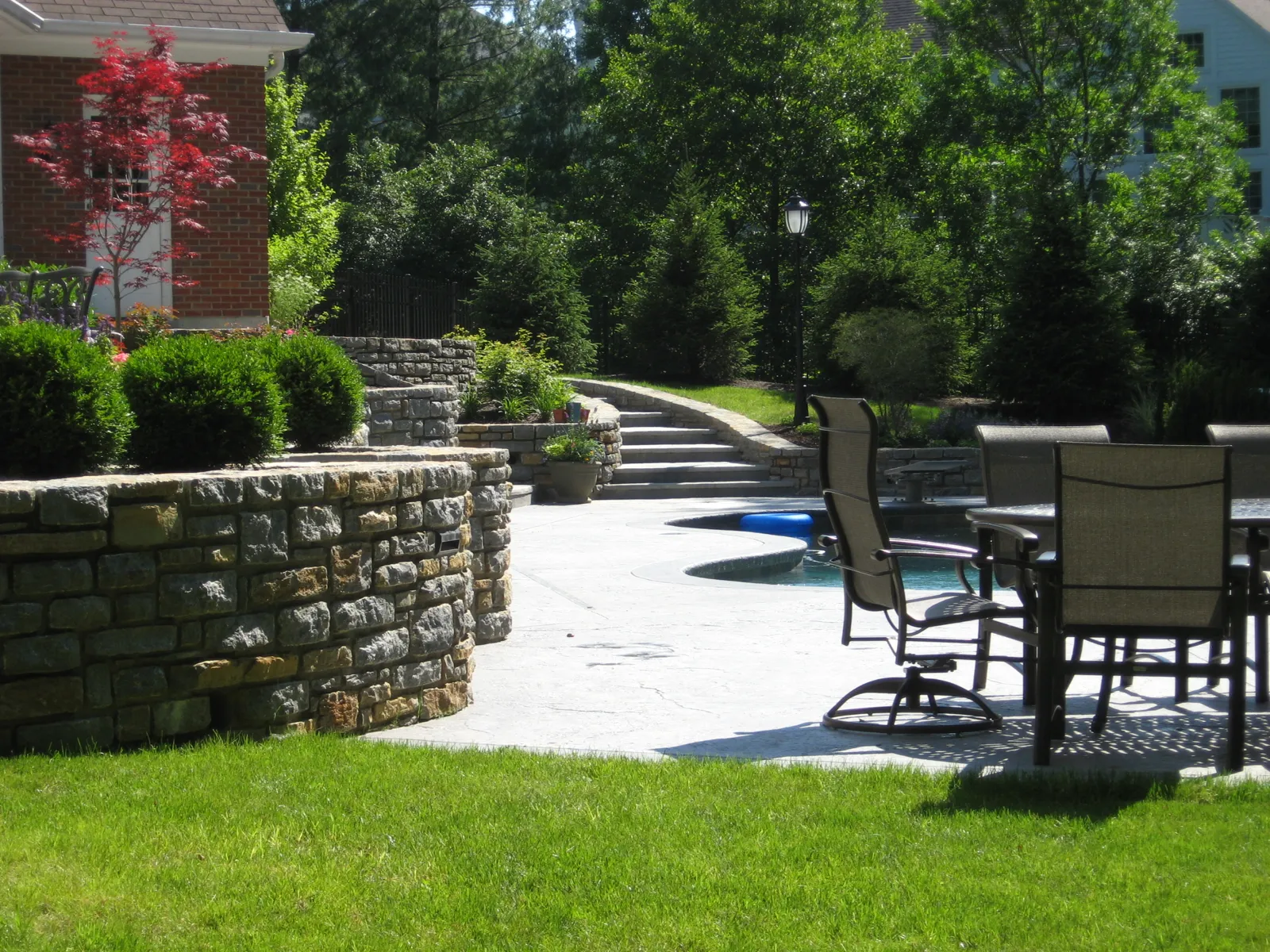 Curved stone walls and terrace steps beside the pool