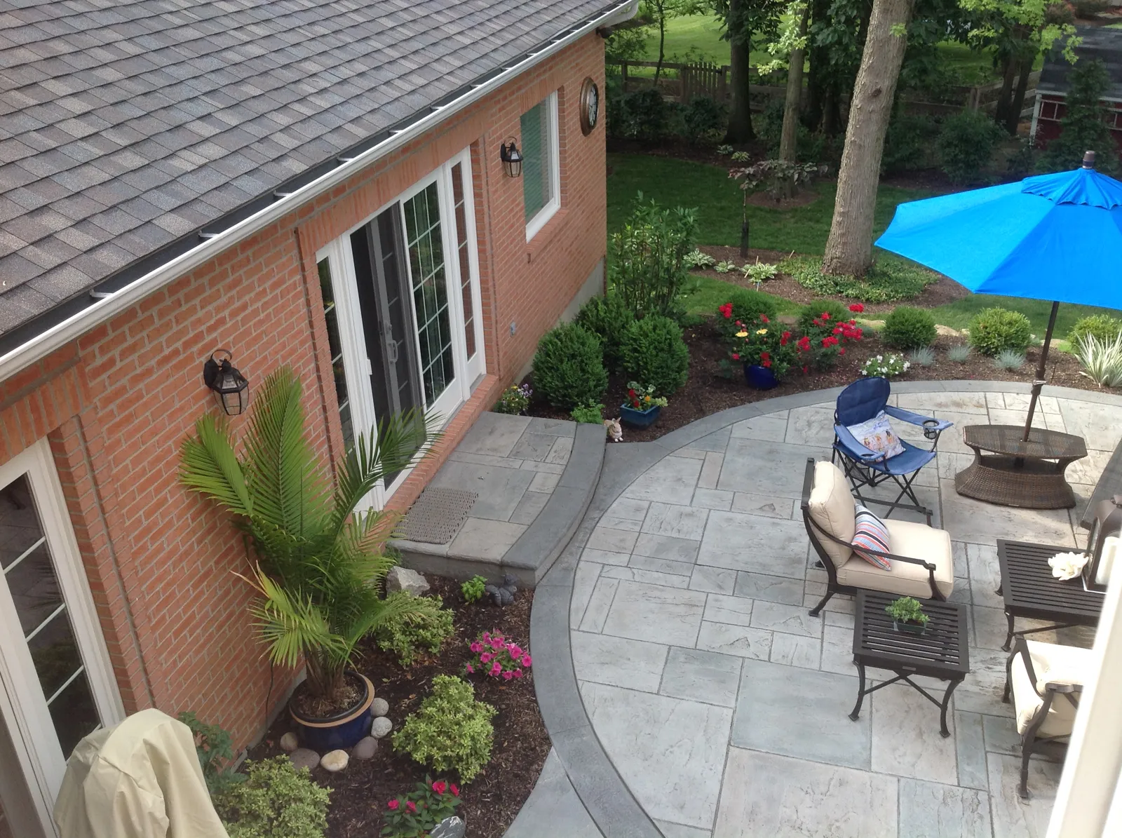 Stamped concrete patio wrapped in colorful planting beds