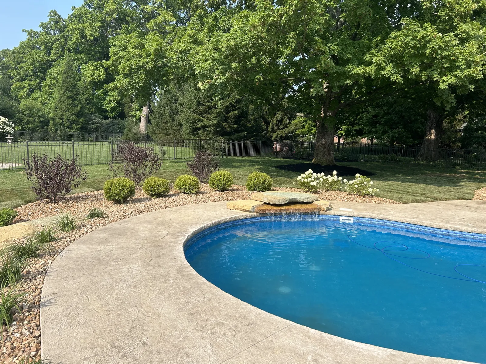 Freeform pool bordered by boulders and plantings
