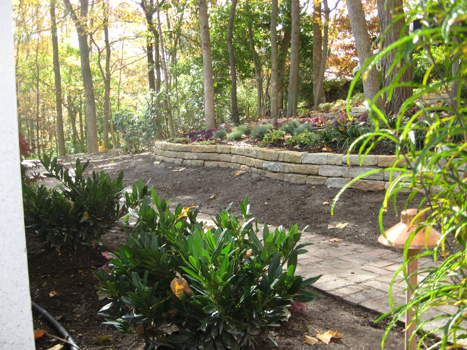 Stacked limestone retaining walls framing a paver walkway
