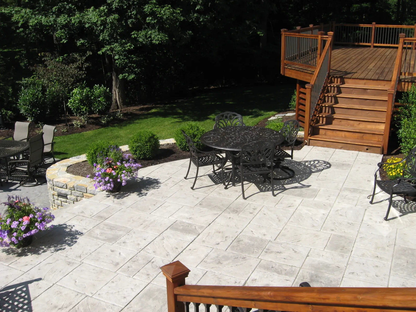 Stamped concrete dining patio below a custom wood deck