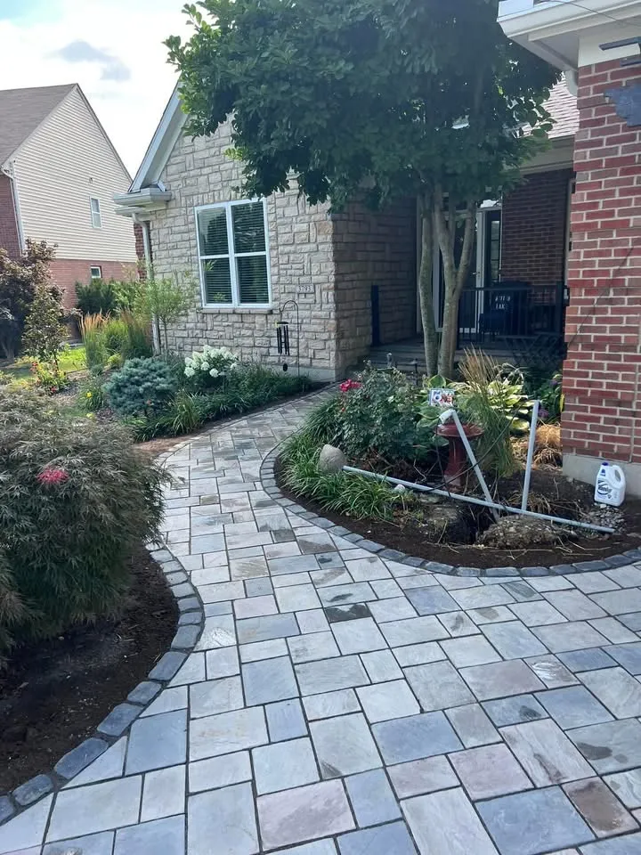 Paver walk winding through garden beds to the front door
