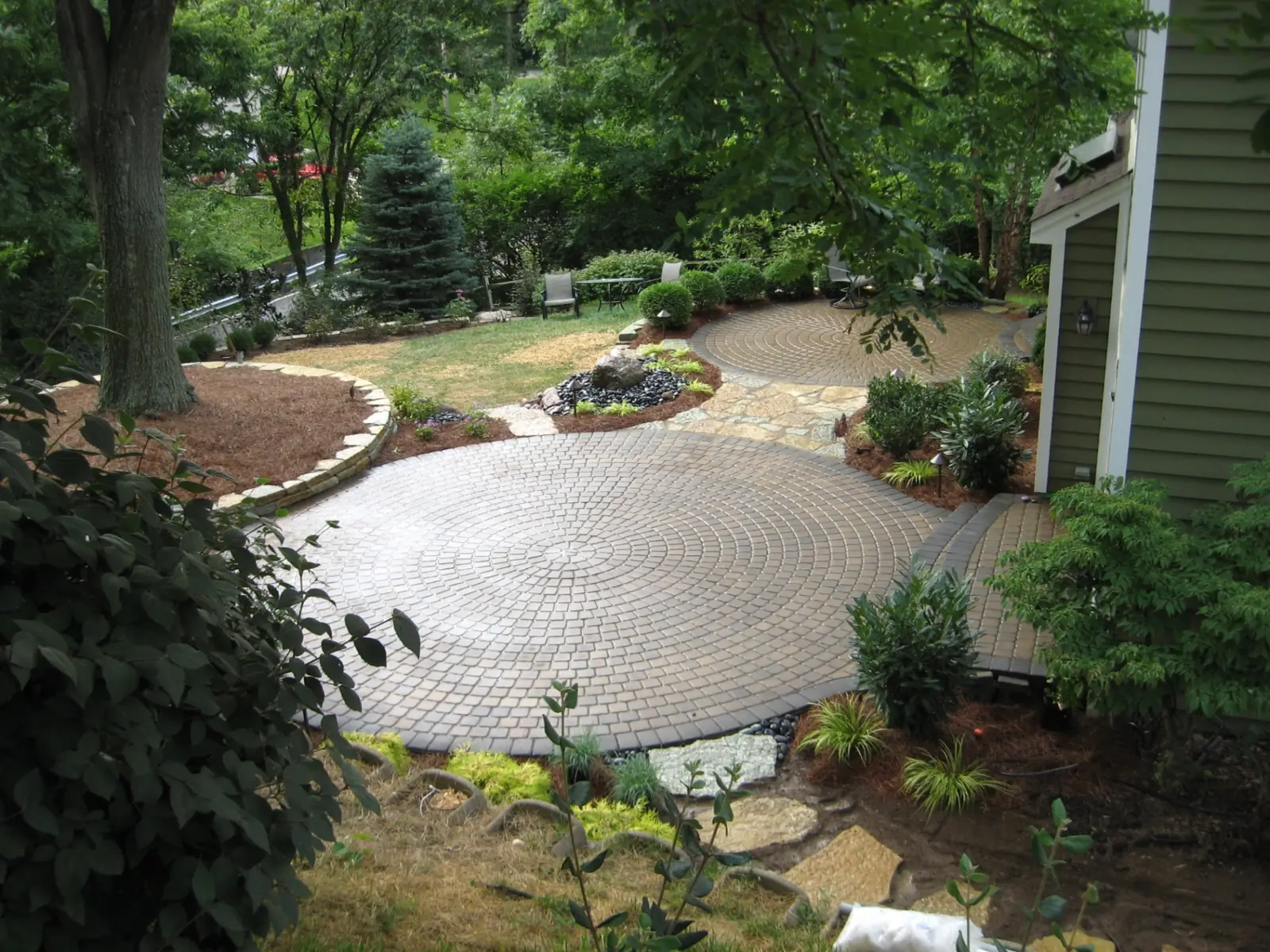 Concentric circular paver patio integrated into mature gardens