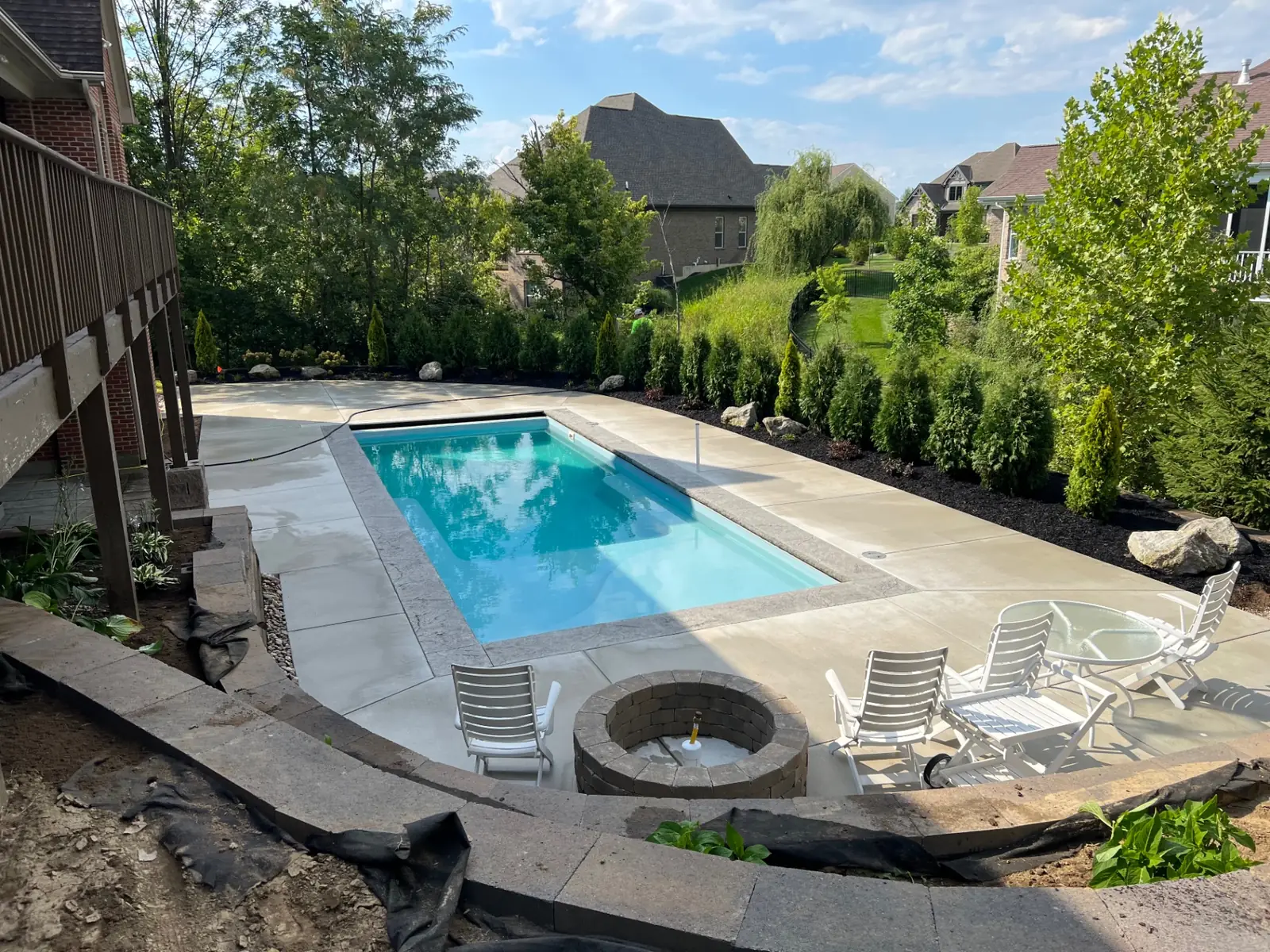 Paver pool deck and gazebo hardscape bordered by a manicured lawn